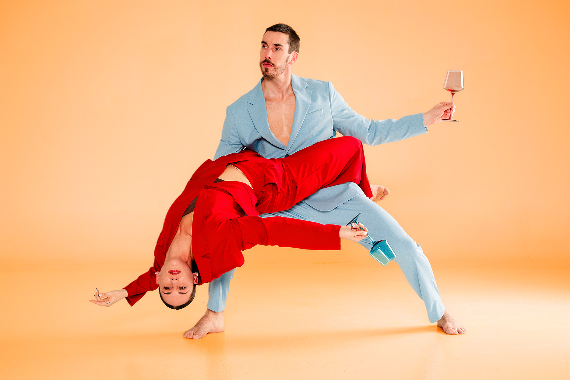 Deux interprètes composent un équilibre dansé sur un fond orangé